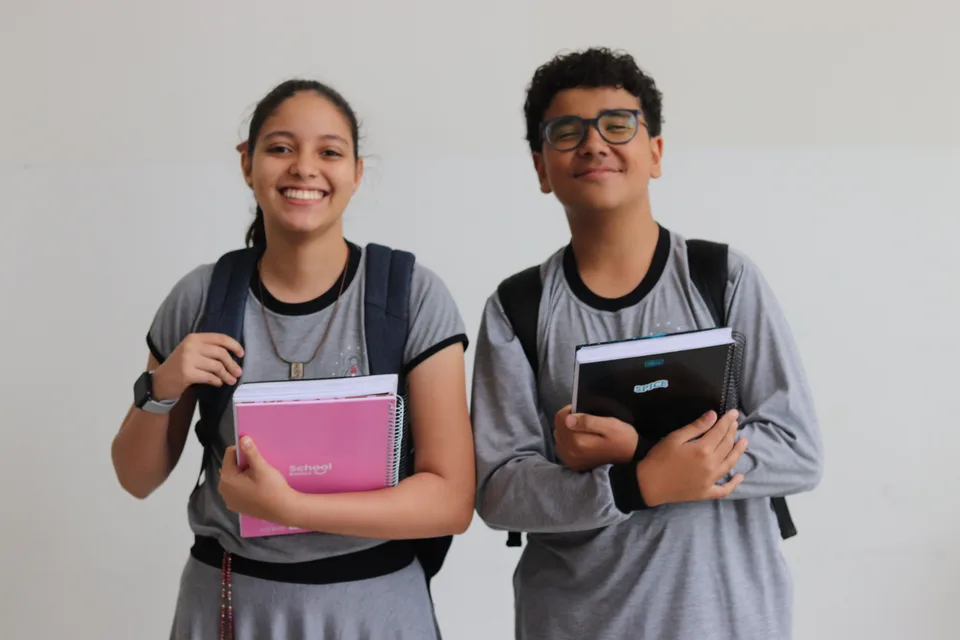 Dois alunos com livros e cadernos