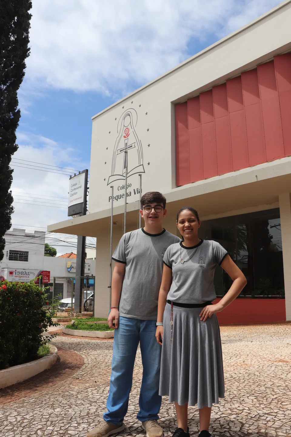 Dois alunos junto à fachada do colégio