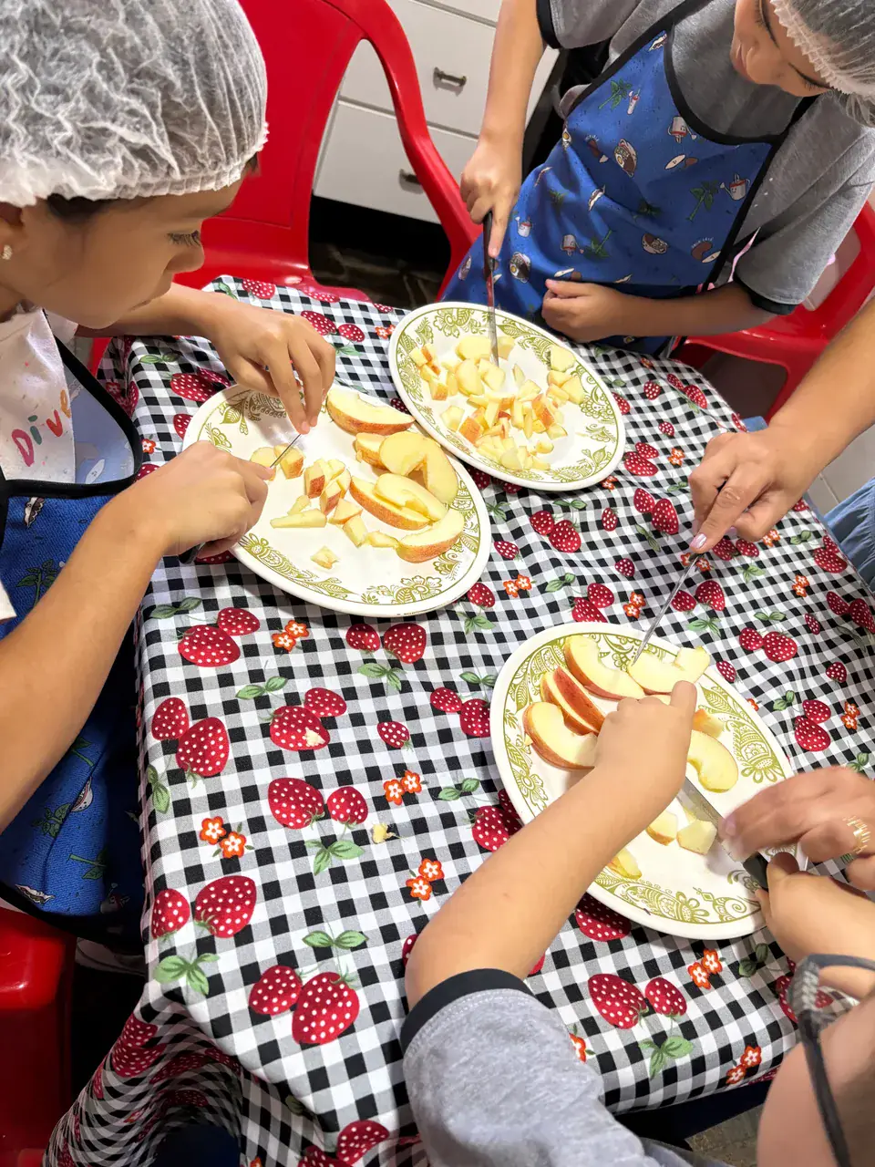 Mãos de crianças preparando alimentos em atividade de culinária